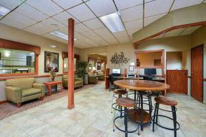 a lobby with a table and chairs and a living room at Studio 6 - Minot, ND in Minot