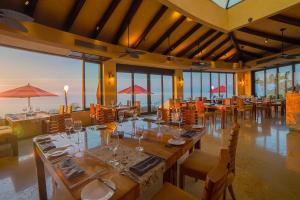 a dining room with tables and chairs and windows at Suites at Garza Blanca Preserve Resort & Spa in Puerto Vallarta