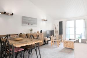 een keuken en eetkamer met een houten tafel en stoelen bij Appartement Arôme in Saint-Martin-de-Ré