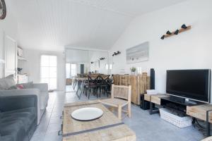 サン・マルタン・ド・レにあるAppartement Arômeのソファとテレビのあるリビングルーム +3枚の写真