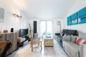 een woonkamer met een bank en een tv bij Appartement Arôme in Saint-Martin-de-Ré