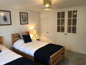 a bedroom with two beds and a lamp at Hill Cottage in Weston-super-Mare