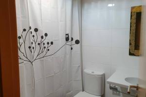 a bathroom with a toilet and a shower curtain at CALA HOUSE I Espacioso apartamento céntrico, aire acondicionado y parking incluido in Peñíscola +19 photos