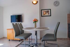 stół z dwoma krzesłami i wazon z kwiatami w obiekcie Apartments Daira - great location w mieście Stomorska