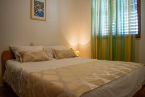 a bedroom with a large bed with a window at Apartments Daira - great location in Stomorska