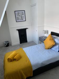 a bedroom with a yellow blanket on a bed at Number 48 in Salisbury