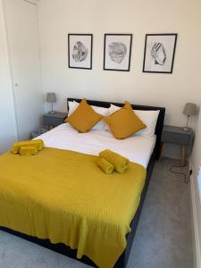 een slaapkamer met een groot bed met gele lakens en kussens bij Number 48 in Salisbury