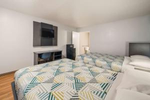 a bedroom with two beds and a flat screen tv at Motel 6-Laredo, TX - North I-35 in Laredo