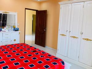 een kamer met een rood-blauw geblokt tapijt in een keuken bij dakar Mbao in Mbaw