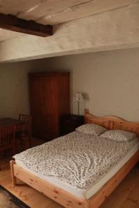 a bed in a bedroom with a wooden bed frame at Pensjonat Stary Spichlerz in Ełk