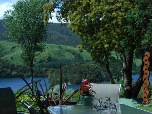 a table and chairs with a view of a lake at The Tuai Suite Waikaremoana in Tuai