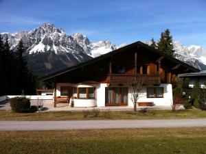 a house with a mountain in the background at Captivating Holiday Apartment in Ellmau in Ellmau