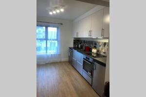 uma cozinha com armários brancos e electrodomésticos azuis em Avila Luxury Living Dungarvan em Dungarvan
