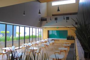 a cafeteria with tables and chairs and a classroom at Holiday Inn Morelia, an IHG Hotel in Morelia