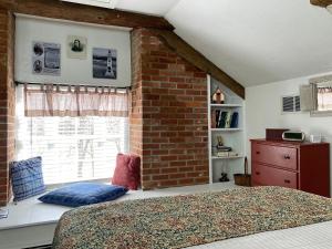 a bedroom with a brick wall and a bed and a window at Lightner Farmhouse B&B in Gettysburg