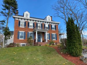 Casa de ladrillo grande con ventanas azules y patio en Lightner Farmhouse B&B en Gettysburg