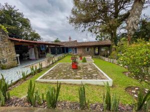 un jardín frente a una casa en Hotel Hacienda San Bartolo, en Xico