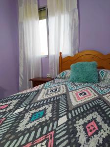 ein Schlafzimmer mit einem Bett mit einer Decke darauf in der Unterkunft Apartamento Playa de Almería - Playa del Zapillo 2 in Almería