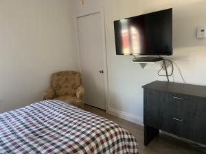 1 dormitorio con 1 cama y TV en la pared en Gestion clin d’oeil - 505, en La Tuque