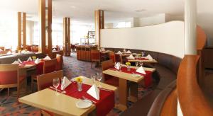 a restaurant with tables and chairs and a whiteboard at Sunday Hotel Wiesbaden Niedernhausen Apartments in Niedernhausen