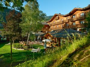 een hotel in de bergen met een groen gazon bij Hotel Beauregard in La Clusaz