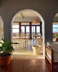 Habitación con comedor con mesas y sillas. en Posada del Barco, en La Pedrera