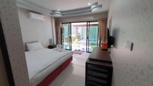 a bedroom with a bed and a desk and a television at Dang Sea Beach Resort - SHA in Nai Yang Beach +41 photos
