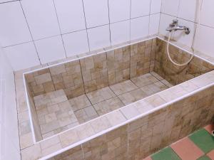 a bathroom with a tub with a shower at 楓情汽車旅館 in Pingtung City