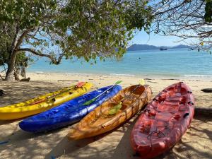 a group of kayaks lined up on a beach at The Reef Resort in Koh Kradan