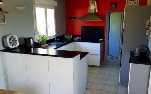 a kitchen with white cabinets and a black counter top at Maison de vacances bord de mer Sibiril Moguériec finistère la villa Léonie in Sibiril +37 photos