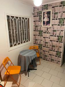 a room with a table and chairs and a wall of books at Homestay Studio in Yaoundé