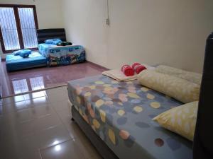 - une chambre avec 2 lits dans l'établissement RUMAH PAKSI HOMESTAY, à Tanjungkarang
