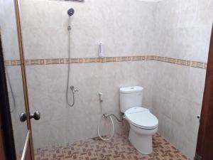 a bathroom with a toilet and a shower at RUMAH PAKSI HOMESTAY in Tanjungkarang