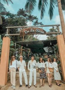 a group of people standing under a sign at a beach at Homestay De la Rosa - Côn Đảo in Con Dao