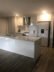 a kitchen with a white counter and a refrigerator at Brand new 4br get away 5min to albury city in Lavington