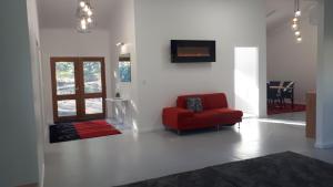 a living room with a red chair and a tv at Stay @ The Cube in Montville