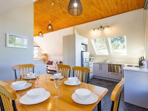 a kitchen and dining room with a wooden table and chairs at The Gingerbread House - Ohakune in Ohakune