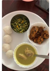einen Teller mit einem Teller Suppe und anderen Lebensmitteln in der Unterkunft Bluebell homestay in Chikmagalur