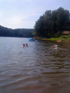 un grupo de personas nadando en un lago en Domki Nad Jeziorem Karłowice, en Karłowice