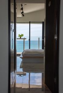 a room with a bed and a view of the ocean at BEACH FRONT VILLA in Baisha