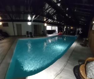 a large swimming pool in a building with a blue pool at BEST SAINTONGE in Port-dʼEnvaux