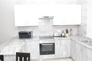 a white kitchen with a sink and a stove at Royal Luxury Hotels and Apartments in Kitwe