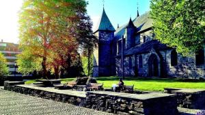 a person sitting on a bench in front of a church at Bnb Central Apartment Stavanger nicolas 4 in Stavanger