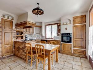 MontagnyにあるModern Holiday Home in Montagny with Balconyのキッチン(木製キャビネット、テーブル、椅子付)
