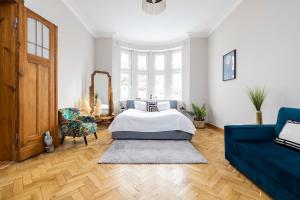 1 dormitorio con 1 cama y 1 sofá azul en Apartament Chrobrego z Balkonem Przy Plaży - Praia Apartments, en Sopot