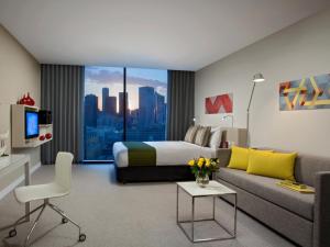 a living room filled with furniture and a tv at Citadines on Bourke Melbourne in Melbourne