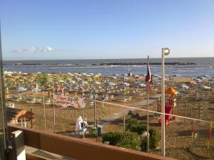 里米尼的住宿－超級酒店，海滩上放着一把遮阳伞,大海