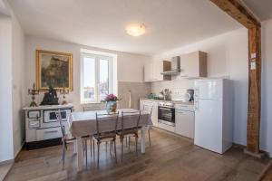 a kitchen with a table and a white refrigerator at Historic Old Town apartment with the best view in town in Poreč