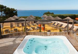 a hot tub on a deck next to a beach at Hôtel & Spa Les Mouettes in Argelès-sur-Mer