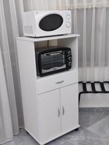 un microondas sentado en la parte superior de un armario blanco en Carmela Studio, en Arad